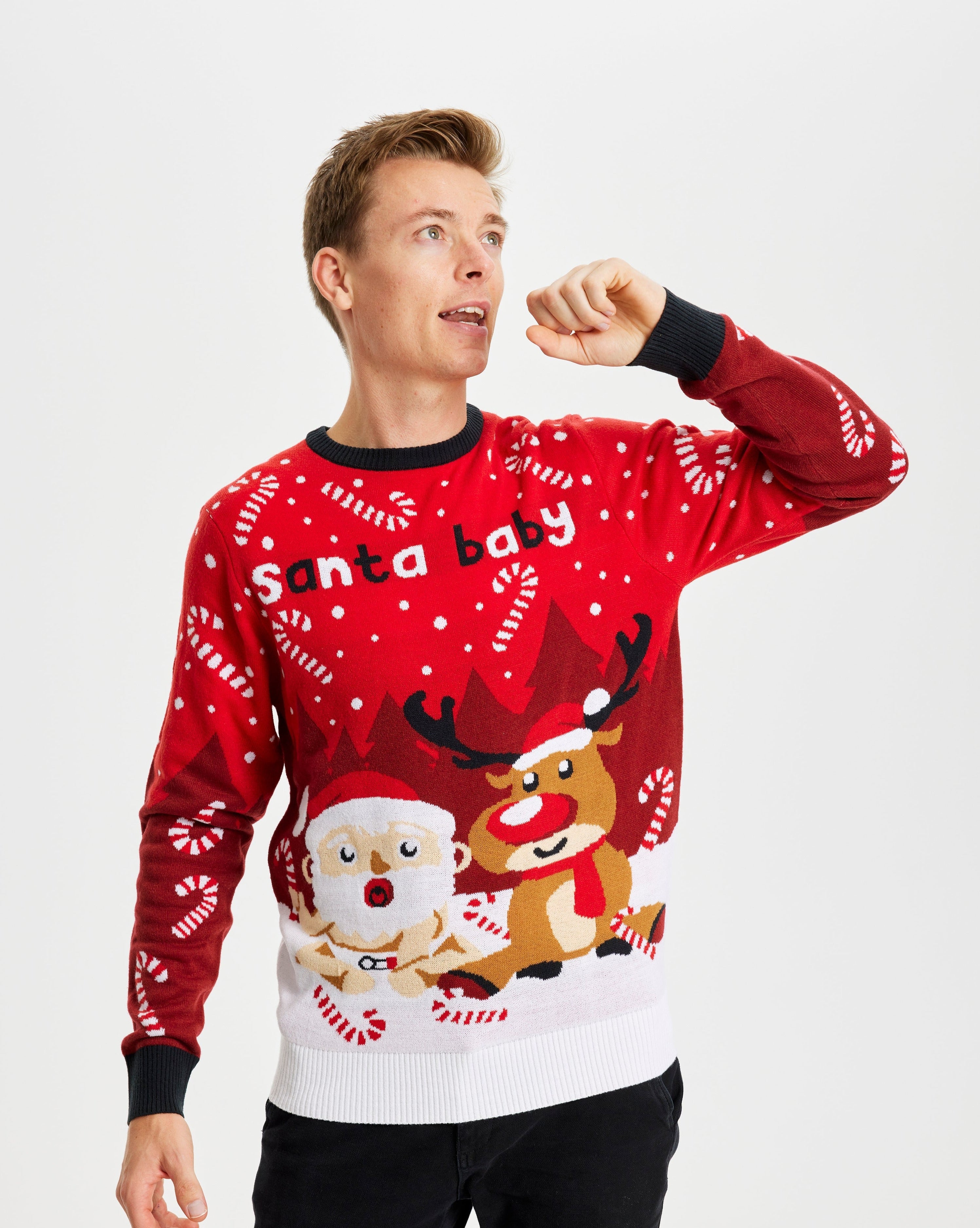 En poserende dame iført en rød julesweater med et rensdyr og en julemand på.